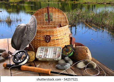 Traditional fly-fishing rod with equipment beside a lake