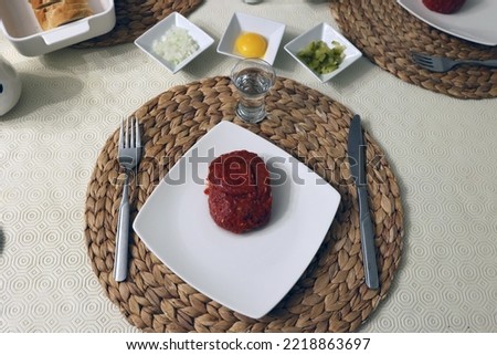 Traditional food of raw meat on a plate and a glass of vodka.