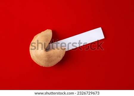 Traditional fortune cookie with empty white note on red background