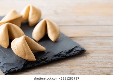 Traditional fortune cookies on wooden table. Copy space - Shutterstock ID 2311283919