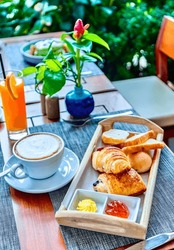 
Traditionelles Französisches Frühstück - Croissants, Baguettes, Toastbrot, Marmelade Und Latte Kaffee, Orangensaft Mit Blumen. Makro. Nahaufnahme. Französische Küche. Gourmetessen.
