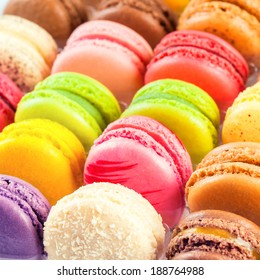 Macarones tradicionales franceses de colores en una fila de la caja. Hay dulces de confección a base de merengue que a menudo se confunden con los macarons.
