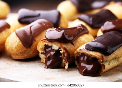 Traditional French dessert. Eclair with chocolate icing. Wooden background