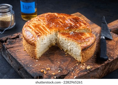 Traditional French gateau basque cake with vanilla cream and pate sablee served as close-up on a rustic wooden board 