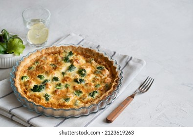 Traditional French pie with cheese and broccoli on a light table. Flan. Copy space.
