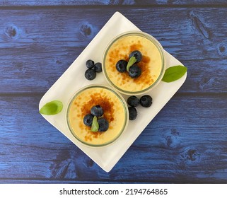 Crème Brûlée, Traditional French Vanilla Cream Dessert With A Caramel Crust, And Served With Blueberries.