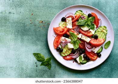 Traditional fresh vegetable greek salad on a plate over green slate, stone or concrete background. Top view with copy space. - Powered by Shutterstock