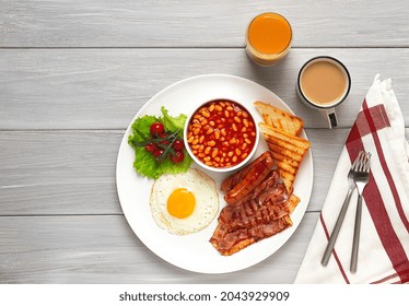 Traditional Full English Breakfast, On A White Background, Fried Eggs With Fried Bacon, Sausages, White Beans ,cherry Tomatoes, Horizontal, No People,