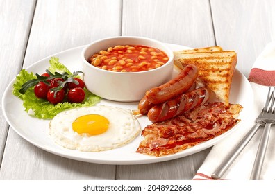 Traditional Full English Breakfast, On A White Background, Fried Eggs With Fried Bacon, Sausages, White Beans ,cherry Tomatoes, Horizontal, No People,