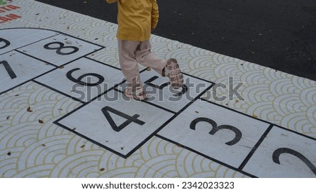 The traditional game involves drawing squares and numbers, by throwing an object into the number box and jumping over it.