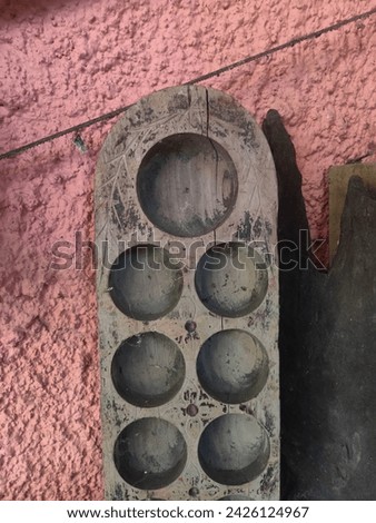 a traditional game at Malaysia. The wooden board with six pits on each side. The four round seeds that sit in each gourd. The satisfying sound the seeds make when you drop them in each pit one by one.