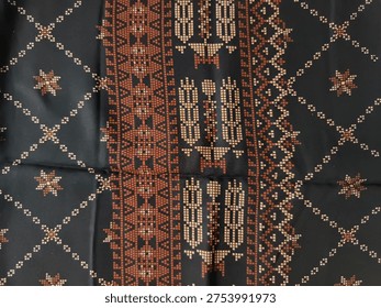 traditional geometric textile pattern on black fabric background with decorative ethnic motif