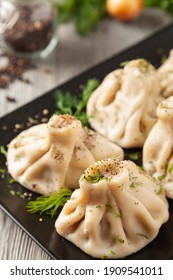 Traditional Georgian dumplings with meat. Khinkali. Served on a plate with traditional Georgian bread. Wooden background. 
