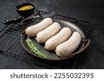 Traditional German Bavarian white sausage in steel tray with mustard. Black background. Top view.