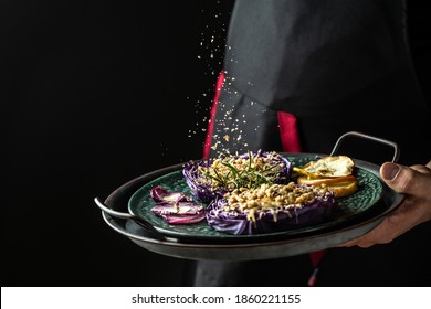 Traditional German Cuisine. Vegetables Dish Of Red Cabbage Baked With Nuts, Quince And Apples, Flying Nuts Scattering In A Freeze Motion.