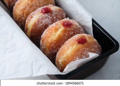 Traditional German Polish Donut with Raspberry Jam Dusted with Sugar. The traditional meal on Fat Thursday, the last day of the carnival.