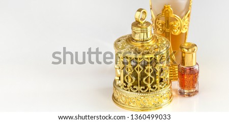 Traditional golden ornate flask of Arabian oud oil perfumes. Isolated white background. Copy space.
