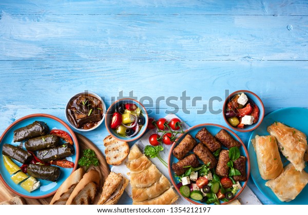 Traditional greek food on a blue wooden\
background.Copy\
space