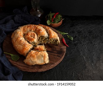 Traditional Greek Pastries. Snail With Cheese And Spinach. Roll With Filling On A Wooden Rustic Table. Copy Space