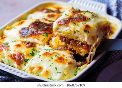 Traditional Greek potato and meat casserole with cheese - moussaka, dark background. Greek cuisine concept.