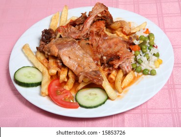 Traditional Greek Rabbit Stifado, Or Stew, At A Taverna In Greece, Served With French Fries, Rice And Vegetables.