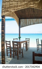 Traditional Greek Taverna, Koufonisi Island, Greece Simple Seaside Restaurant By The Beach. Vertical Shot.  No People.  Blurred Background With Copy Space.