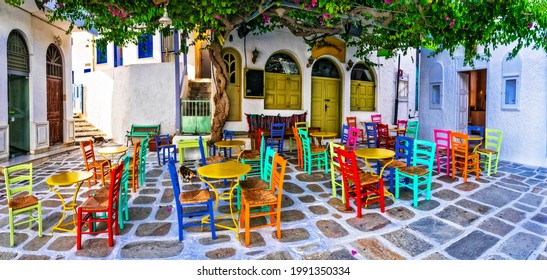 Traditional Greek taverns on the streets. Ios island, old town Chora. Restaurant with colorful typical chairs. Cyclades, Greece - Shutterstock ID 1991350334