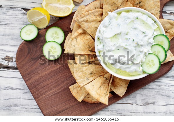 Traditional Greek Tzatziki dip sauce made with\
cucumber sour cream, Greek yogurt, lemon juice, olive oil and a\
fresh sprig of dill weed. Served with toasted Za\'atar Pita bread. \
Top view  or flat\
lay.