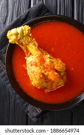 Traditional Guatemalan Kakik Soup Features Dark Turkey Meat In A Delicious, Lightly-spiced Red Broth Closeup In The Plate On The Table. Vertical Top View From Above
