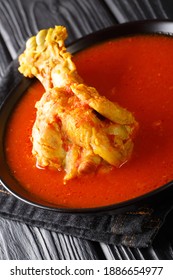 Traditional Guatemalan Kakik Soup Features Dark Turkey Meat In A Delicious, Lightly-spiced Red Broth Closeup In The Plate On The Table. Vertical
