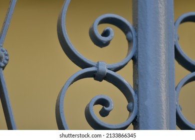 Traditional handcrafted light blue wrought iron entrance gate railing with rosette decorations in Nafplio, Greece.