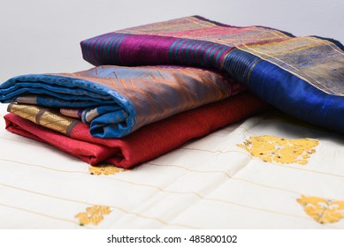 Traditional Handmade White, Red/pink, Blue Indian Silk  Sari /saree With Golden Details,  Woman Use To Wear On Onam Festival, Vishu, Wedding In Kerala India. Close Up Of Stack Of Multi-colored Saree.