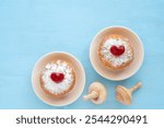 Traditional Hanukkah donuts Sufganiyah, wooden dreidels on blue background. Pastries for Jewish holiday Hanukkah.