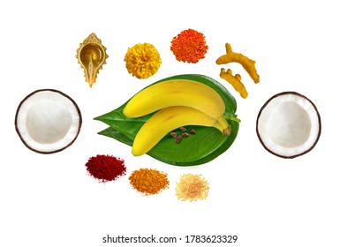 traditional hindu pooja essential items, bannana, betel leaf, betel nuts, coconut, turmeric, kumkum, turmeric sticks, mari gold flower, brass lamp, mango leaf thoranam on white background