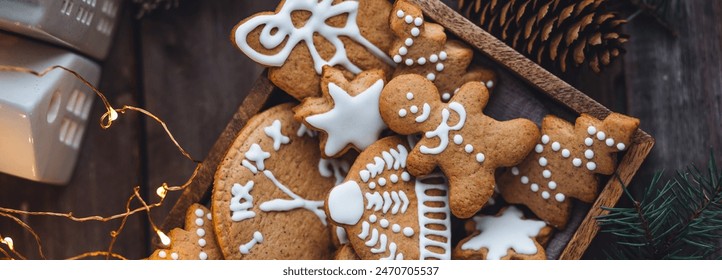 Traditional holiday homemade gingerbread cookies in a vintage wooden box. Craft paper with Christmas word. Festive mood, cozy home atmosphere, handmade toys, fir tree branches, fairy lights banner - Powered by Shutterstock