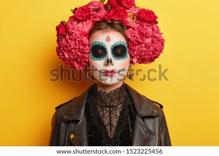 Traditional holiday in November. Female with sugar skull drawn with smile, wears flower wreath, dressed in black clothes, remembers death of ancestors, visits cemetery. Reuniting of living and dead