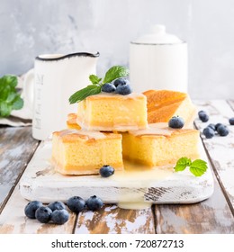 Traditional homemade baked pudding cake with custard cream and blueberries. Healthy dessert.