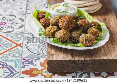 Traditional homemade chickpea falafel balls with white sauce and pita bread on whitw plate on wooden board, healthy vegetarian life concept. Israel Jewish food. Stock photo © 