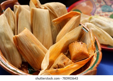 Traditional homemade Mexican food Tamales, Corn dough stuffed with sauce wrapped in corn husk in a clay pot.