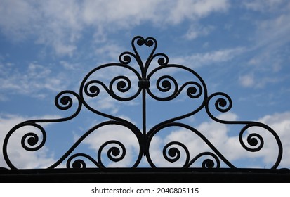 Traditional house custom made wrought iron entrance gate railing against a blue sky in Galaxidi, Phocis Greece. 
