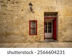 Traditional house detail in Malta. Limestone yellow bricks and colorful balcons, windows