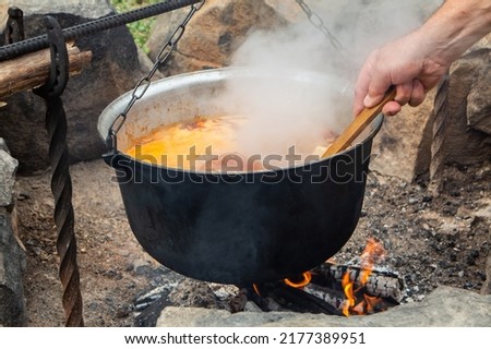 Traditional Hungarian bograch. Cooking on an open fire. Traditional Hungarian goulash in a cauldron. Transcarpathian dish. Soup with meat and chili pepper.