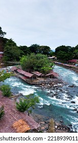 Traditional Huts And Trees Between River Fork In A Village