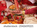 Traditional Indian Bengali Hindu Wedding Hand, Indian Wedding rituals, Customs and Traditions for bride or Dulhan. Pandit performing holy pooja. Shagun, Mehendi. Couple holding hands during marriage