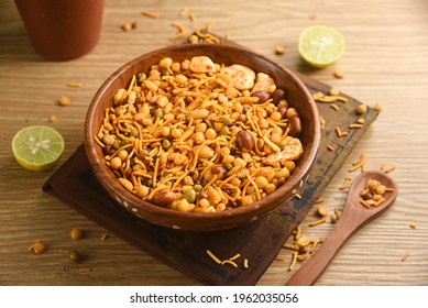 Traditional indian deep fried salty dish - chivda or mixture or farsan or namkeen made of gram flour and mixed with dry fruits. svouries otherwise called as masala mixture chakna with hot tea - Shutterstock ID 1962035056