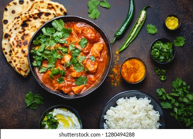 Traditional Indian Dish Chicken Tikka Masala With Spicy Curry Meat In Bowl, Basmati Rice, Bread Naan, Yoghurt Raita Sauce On Rustic Dark Background, Top View, Close Up. Indian Style Dinner From Above 