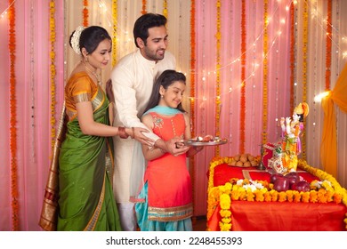 Traditional Indian family worshiping Lord Krishna on Krishna Janmashtami - Festival concept. Stock image of a happy family holding a puja thali together and doing aarti - Hindu culture, spiritual f... - Shutterstock ID 2248455393