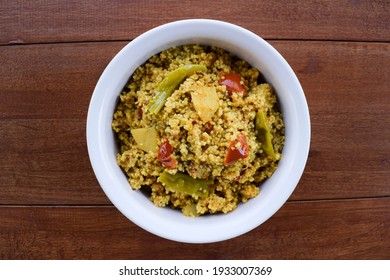 Traditional Indian fasting food recipe dish called Bhagar homemade of Barnyad millet rice grains. Also known as samo or sama pulao rice khichdi. Indian fasting food dish on wooden background - Shutterstock ID 1933007369