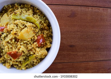 Traditional Indian fasting food recipe dish called Bhagar homemade of Barnyad millet rice grains. Also known as samo or sama pulao rice khichdi. Indian fasting food dish on wooden background - Shutterstock ID 1933008302