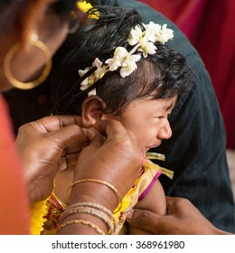 Traditional Indian Hindu Family Having Ear Piercing Ceremony For Baby Girl In One Year Old.